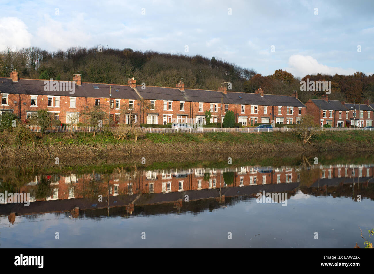 Vista sud, una fila di case a schiera si riflette nel fiume usura, Fatfield, North East England, Regno Unito Foto Stock