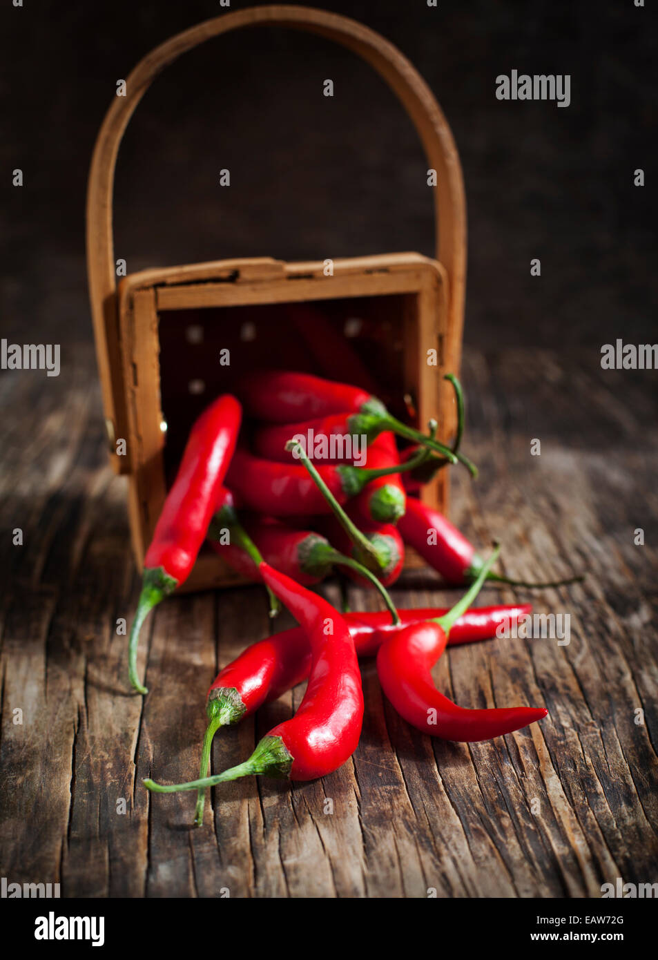 Red Hot Chili Peppers in cesto su sfondo di legno. Messa a fuoco selettiva Foto Stock