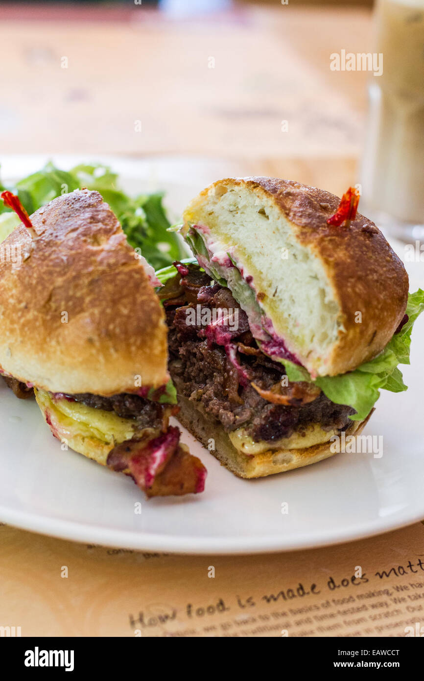 Hamburger tagliati a metà e sulla piastra Foto Stock