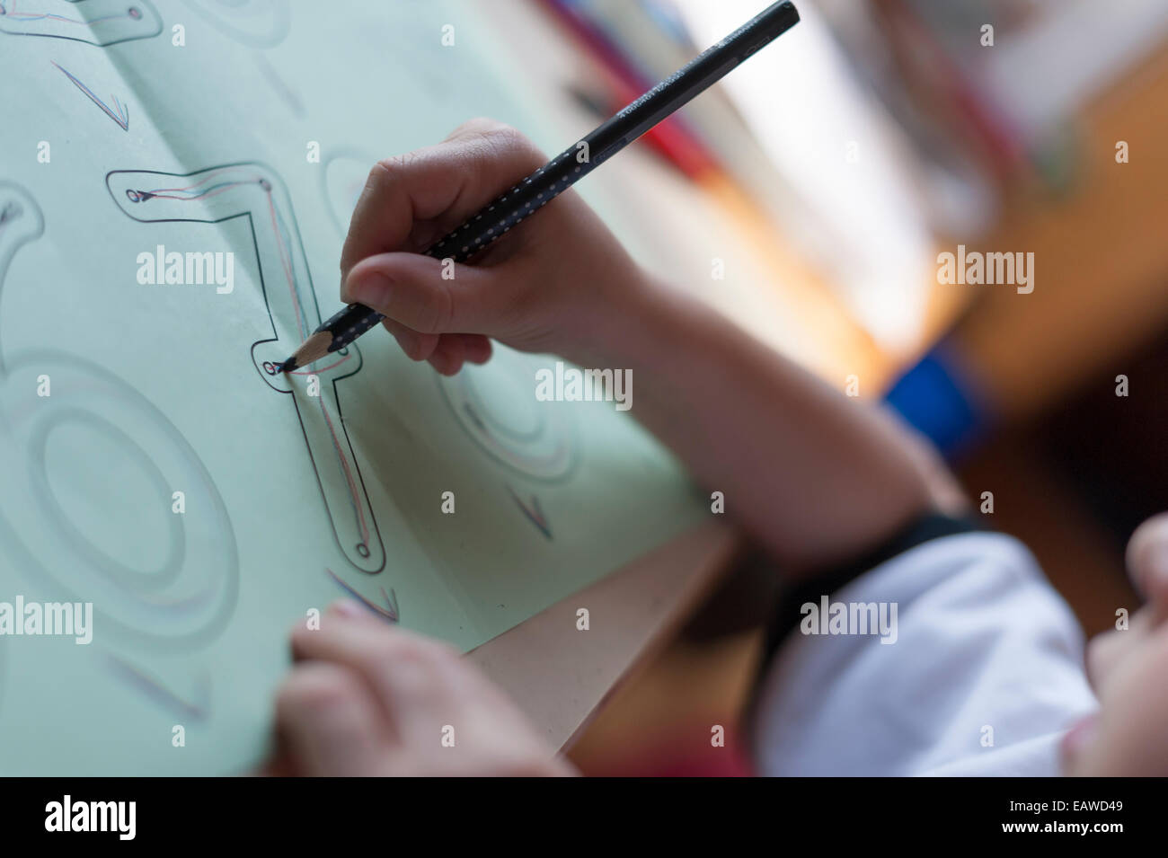 A 7 anno di età schoolchild sta facendo esercizi di scrittura come compiti a casa per la scuola elementare. Foto Stock