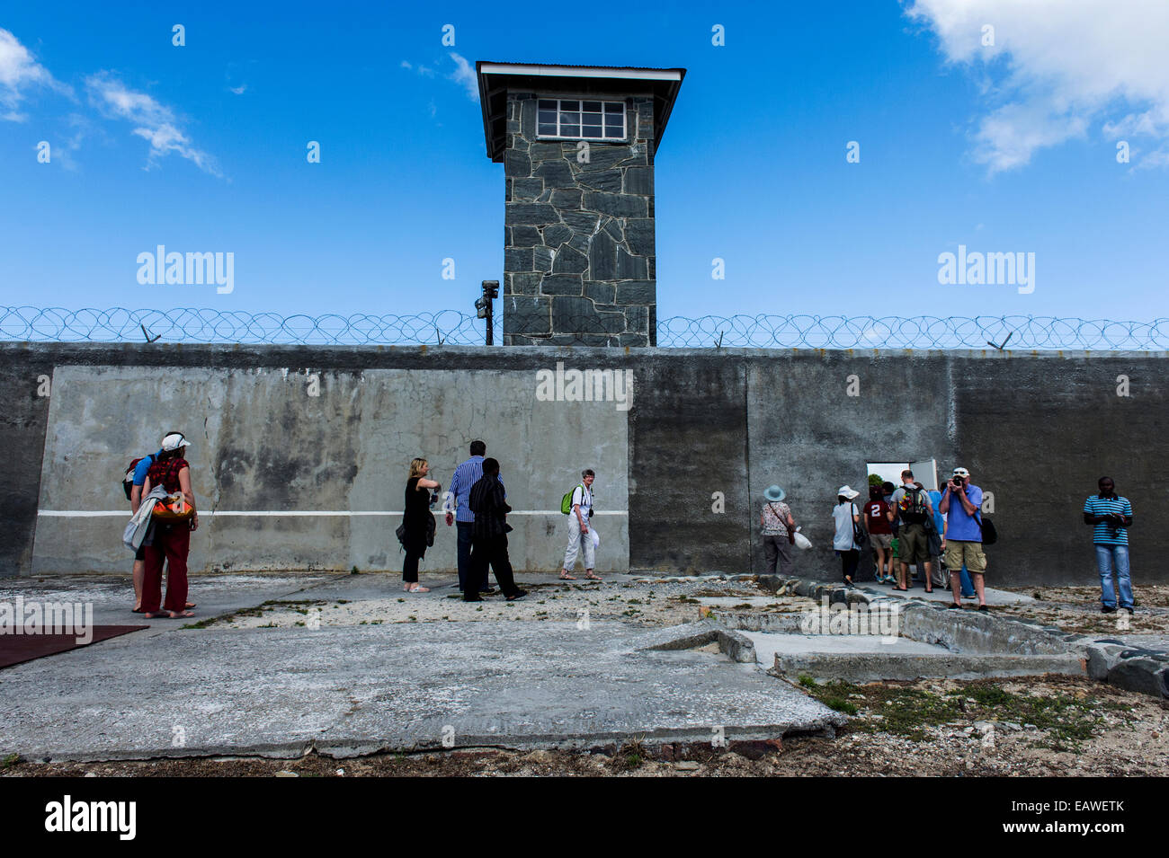 I turisti di esplorare una prigione di cantiere in una gita di Robben Island. Foto Stock