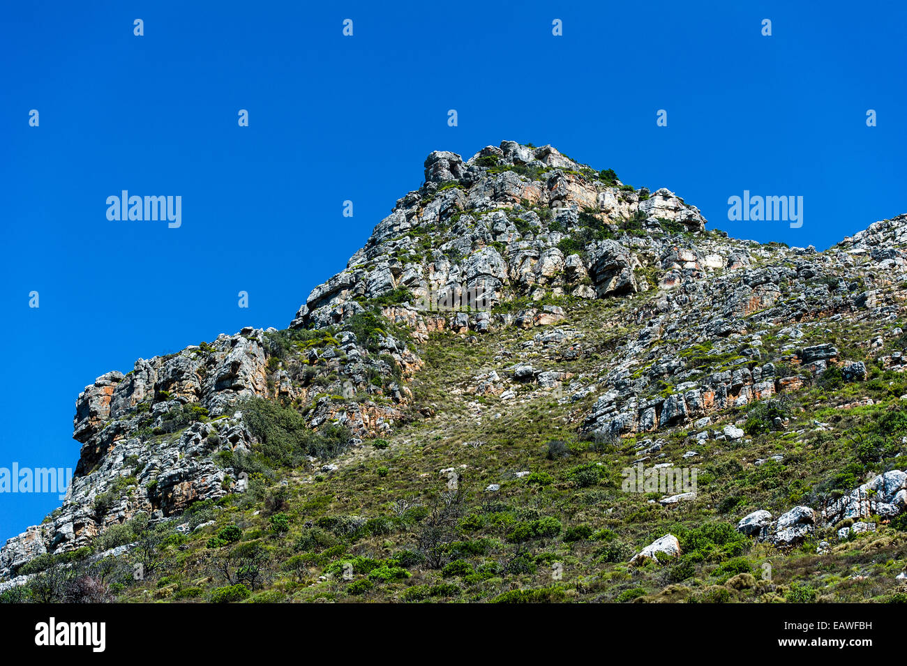 Robusto e weathered mountaintop massi sotto un cielo blu chiaro. Foto Stock