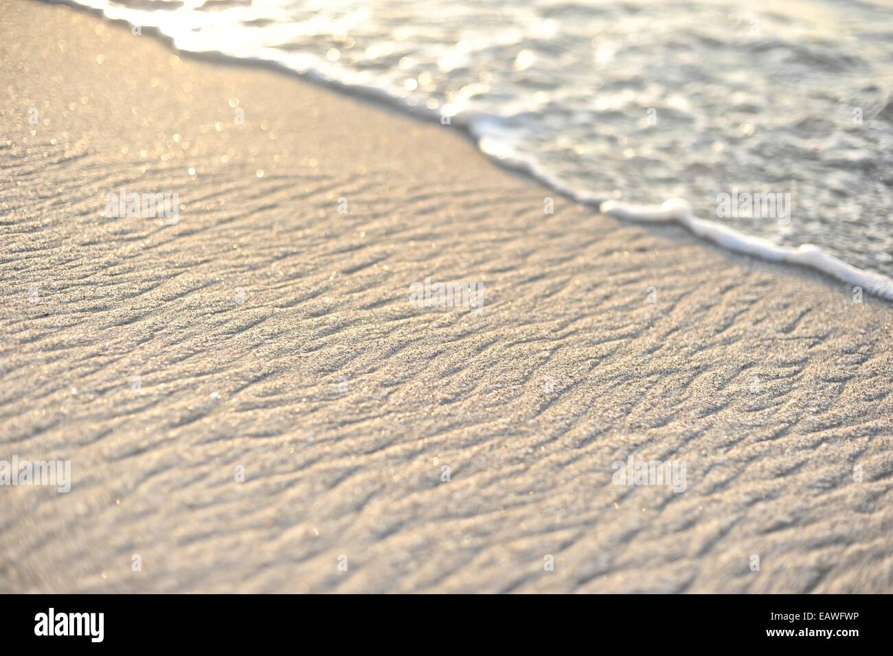 Surf crea un modello naturale spiaggia in sabbia. Foto Stock