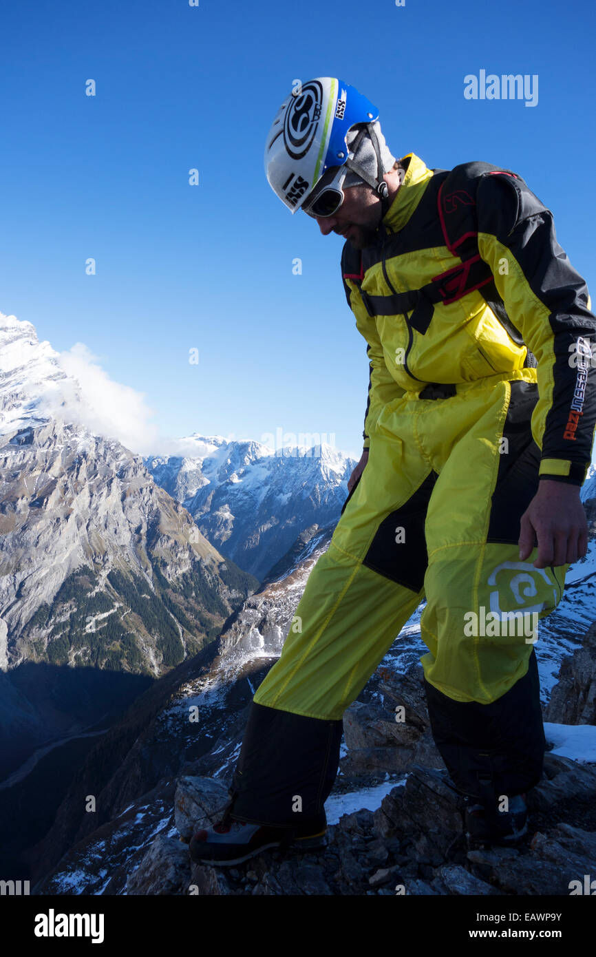 Ponticello di base è la preparazione di se stesso per base jump. In tal modo egli mantenendo le sue braccia e gamba stabile. Foto Stock