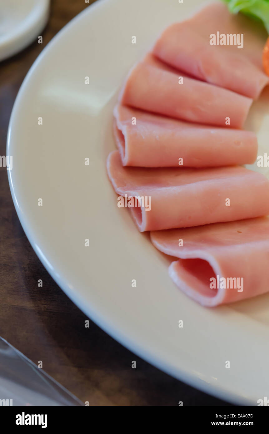 Close up di maiale le fette di prosciutto sul piatto bianco Foto Stock