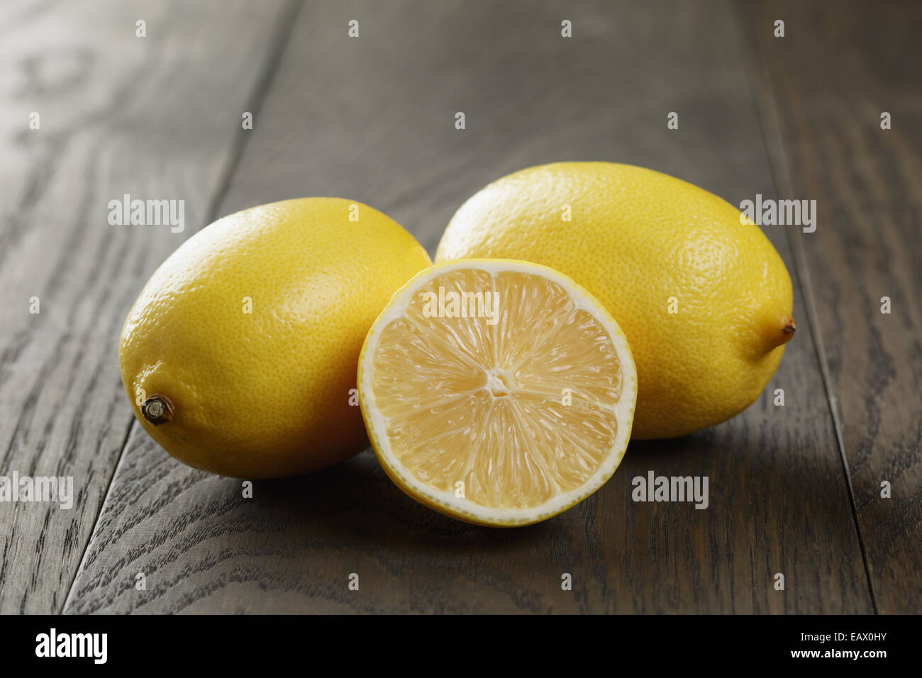 Freschi limoni maturi sul vecchio tavolo in legno di quercia, rustico Foto Stock