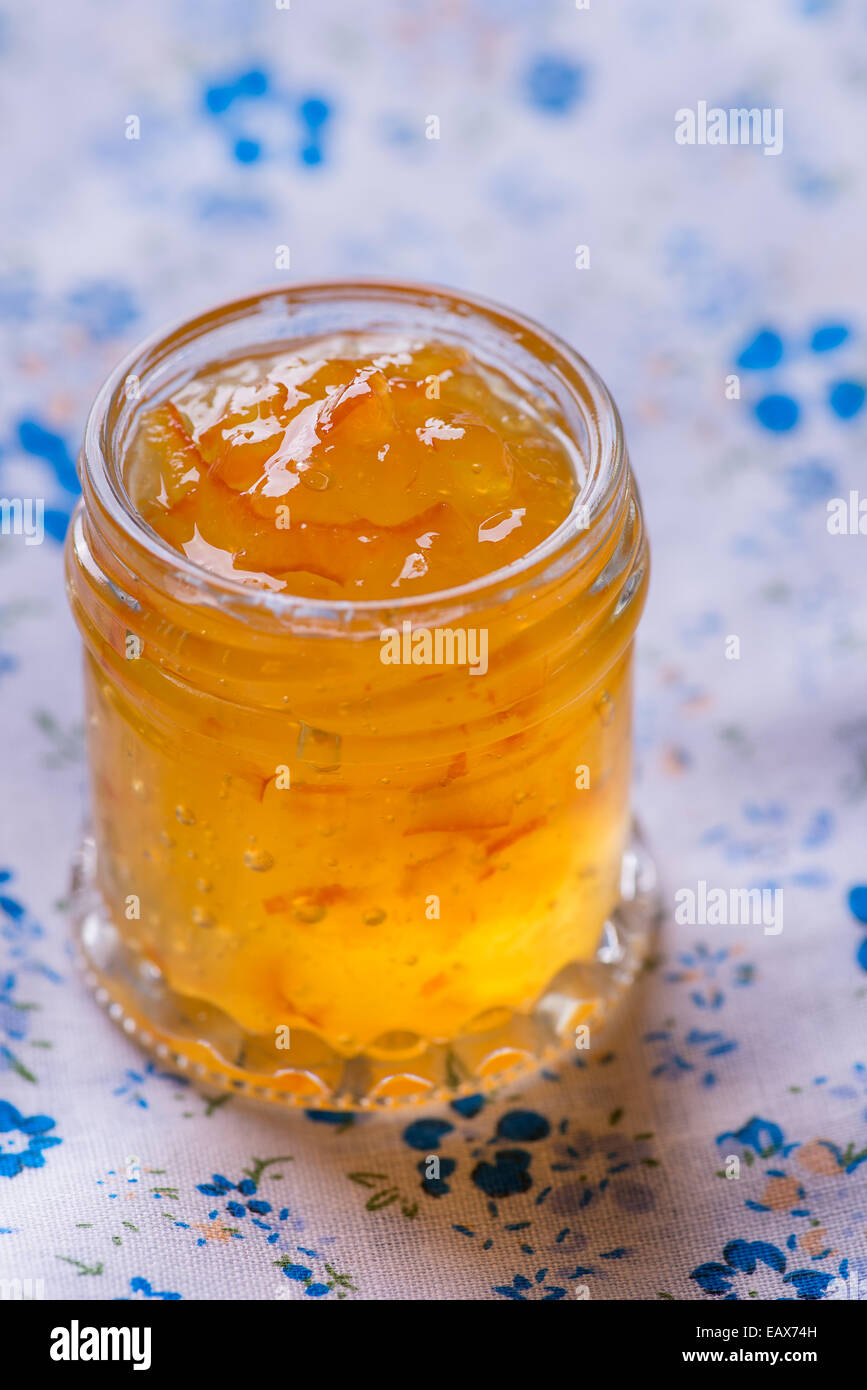 Vaso con marmellata di arancio su blue igienico, il fuoco selettivo Foto Stock