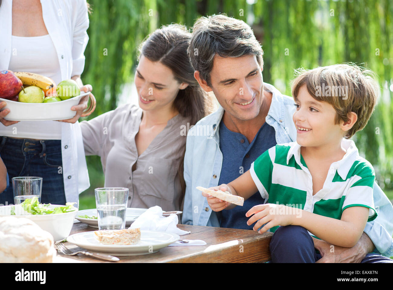 Famiglia mangiare insieme all'aperto, padre figlio di contenimento sul giro Foto Stock