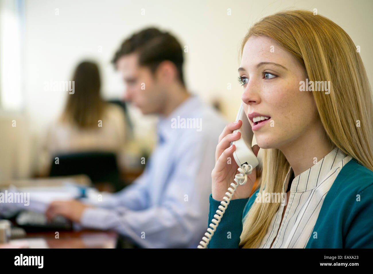 Donna che utilizza il telefono di rete fissa in ufficio Foto Stock