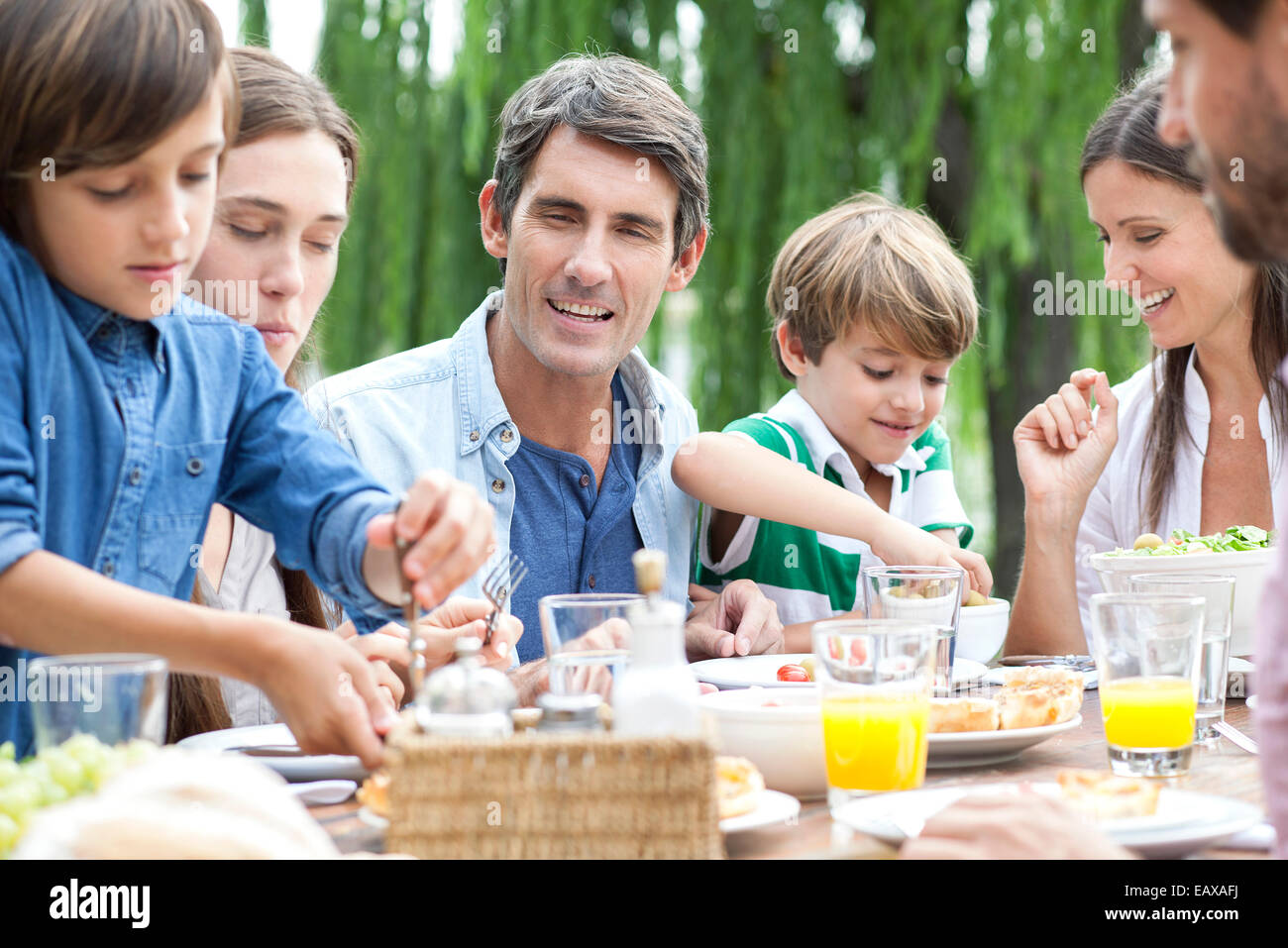 Famiglia mangiare insieme alla raccolta esterna Foto Stock