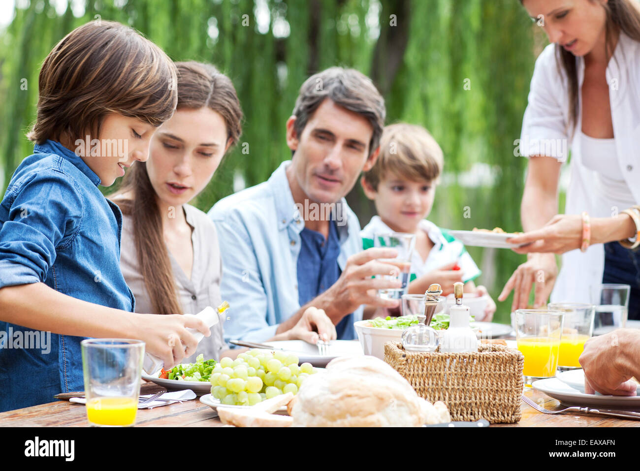 Famiglia mangiare insieme alla raccolta esterna Foto Stock