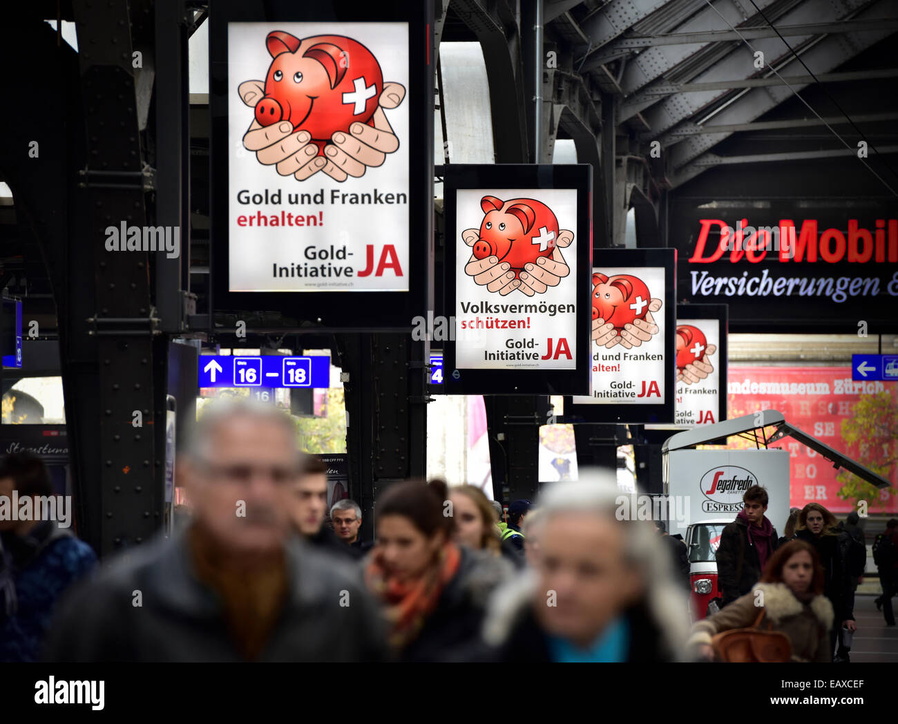 Zurigo, Svizzera. Xxi Nov, 2014. Abbondanza di referendum manifesti della campagna per la svizzera "Gold iniziativa' referendum a zurich main station. Con una settimana a visitare la campagna referendaria del Swiss 'Gold iniziativa' sta andando a piena potenza in tutta la Svizzera. Il controverso referendum è volto a forzare la Banca Nazionale Svizzera per tenere almeno il 20% di tutti i beni in oro fisico. Credito: Erik Tham/Alamy Live News Foto Stock