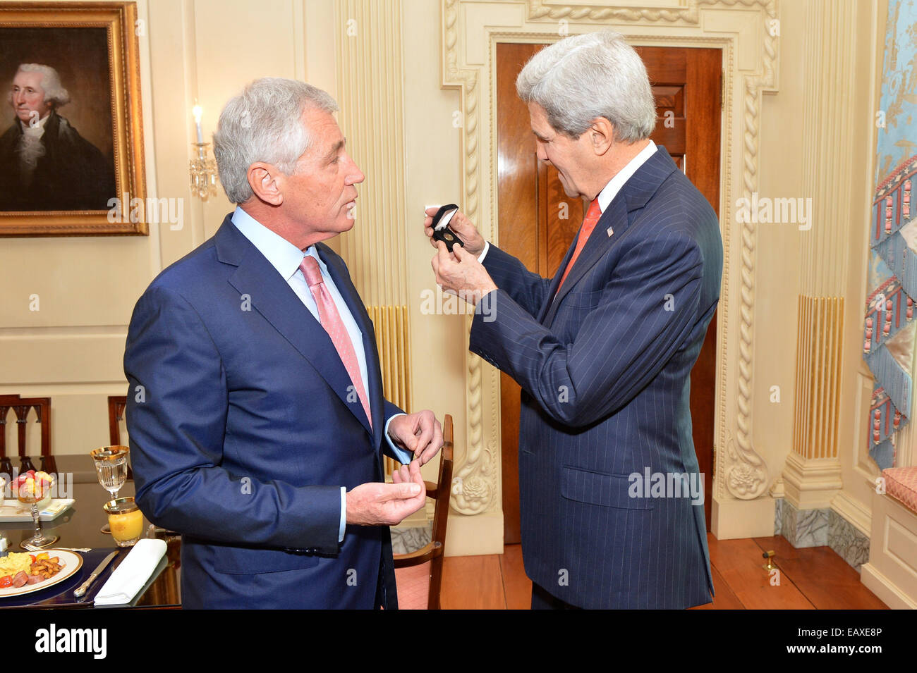 Stati Uniti Il Segretario della Difesa Chuck Hagel presenta U.S. Il segretario di Stato con un nuovo pin per commemorare ufficialmente i veterani del Foto Stock