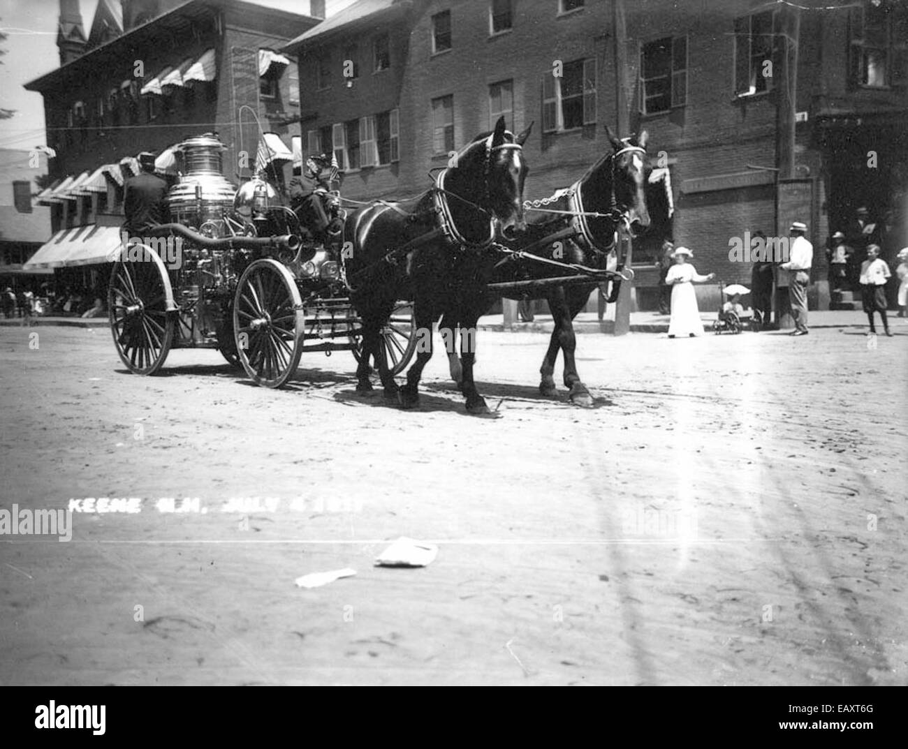 Questa fotografia storica cattura un motore antincendio trainato da cavalli a Keene, New Hampshire, il 4 luglio 1911. L'immagine raffigura la scena della sfilata, mostrando il motore antincendio come parte della festa della comunità. La fotografia offre informazioni sulle tradizioni americane dei primi anni del XX secolo e sulle attrezzature antincendio. Foto Stock