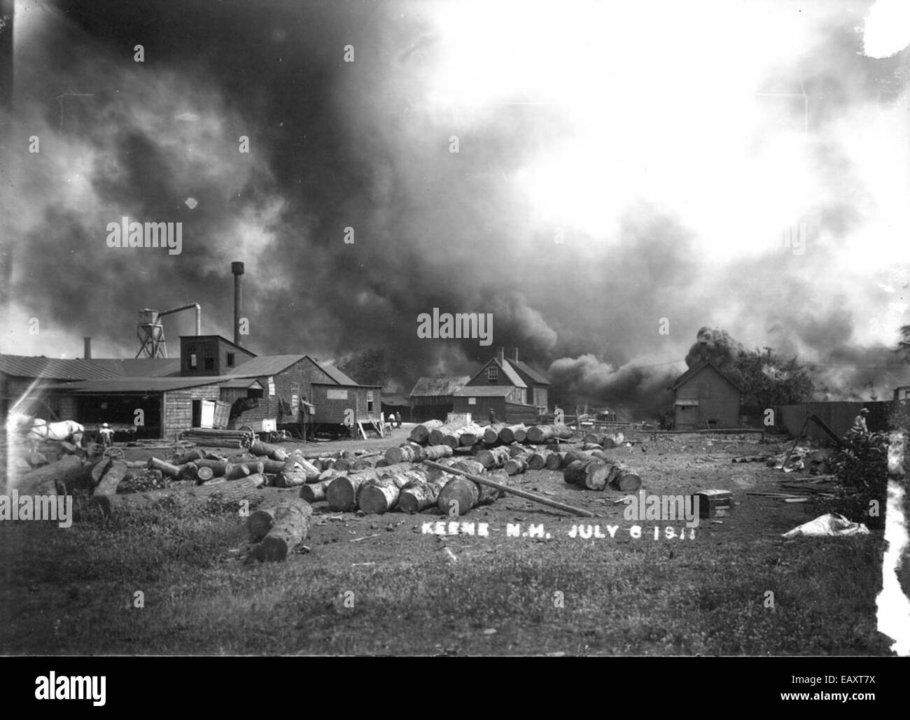 Una fotografia che cattura l'incendio alla segheria della Impervious Package Company a Keene, New Hampshire. L'incendio, che ha inghiottito la segheria, mette in evidenza i rischi e i pericoli che gli impianti industriali devono affrontare. Questa immagine fa parte della storia locale di Keene, che documenta i pericoli di incendio nell'industria del XX secolo. Foto Stock Una fotografia che cattura l'incendio alla segheria della Impervious Package Company a Keene, New Hampshire. L'incendio, che ha inghiottito la segheria, mette in evidenza i rischi e i pericoli che gli impianti industriali devono affrontare. Questa immagine fa parte della storia locale di Keene, che documenta i pericoli di incendio nell'industria del XX secolo. Foto Stock