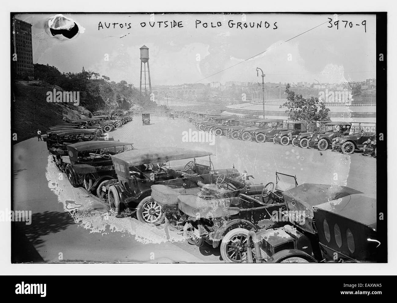 Questa fotografia cattura una fila di auto parcheggiate fuori dal Polo Grounds 147, un sito storico di New York City. Il Polo Grounds fu la casa dei New York Giants e in seguito dei New York Mets prima di essere demolito negli anni '1960 L'immagine riflette la cultura automobilistica della metà del XX secolo e i popolari eventi sportivi che hanno avuto luogo in questo luogo iconico. Foto Stock