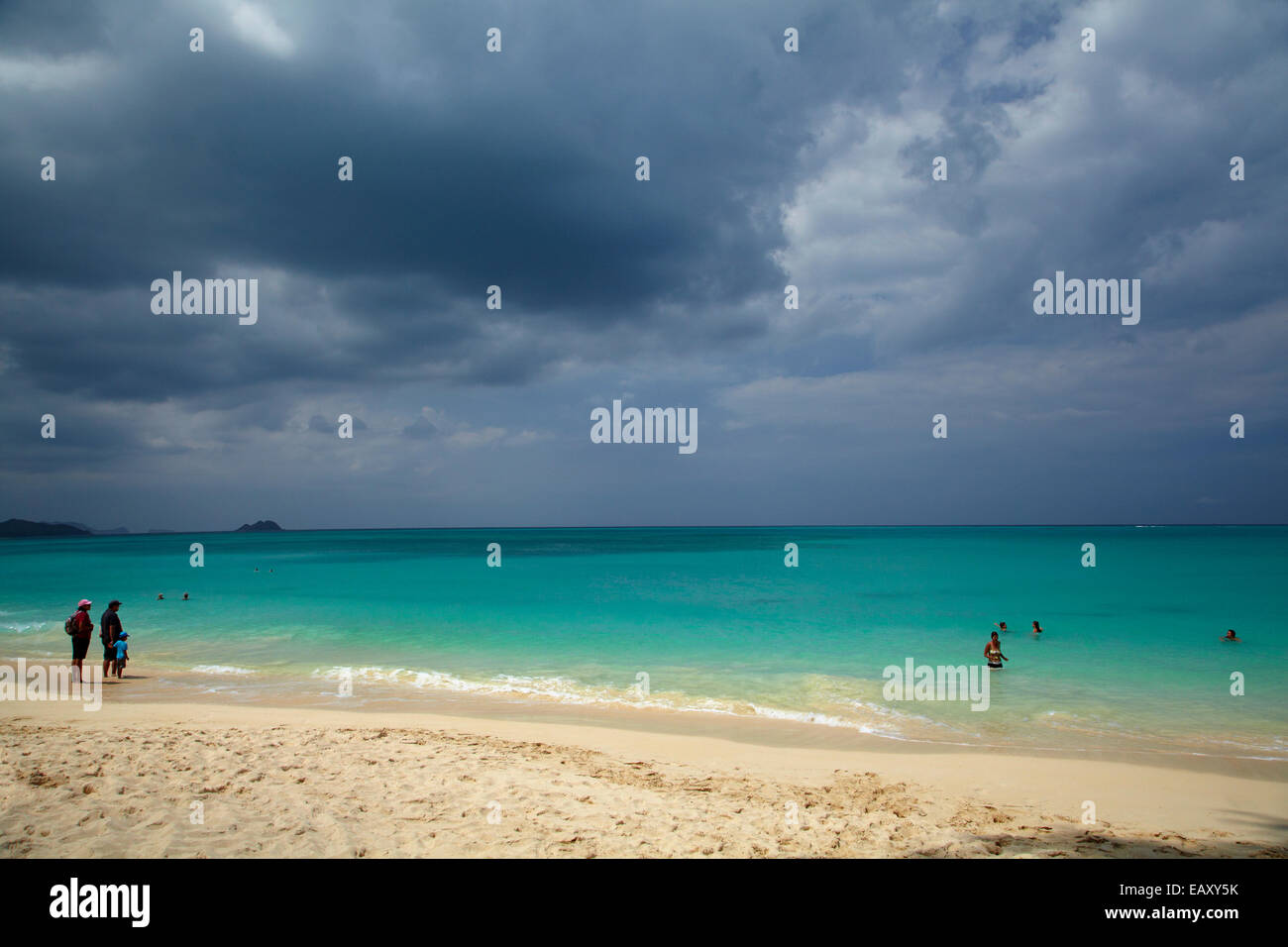 La gente di nuoto a Waimanalo Beach e nuvole di tempesta, Oahu, Hawaii, STATI UNITI D'AMERICA Foto Stock