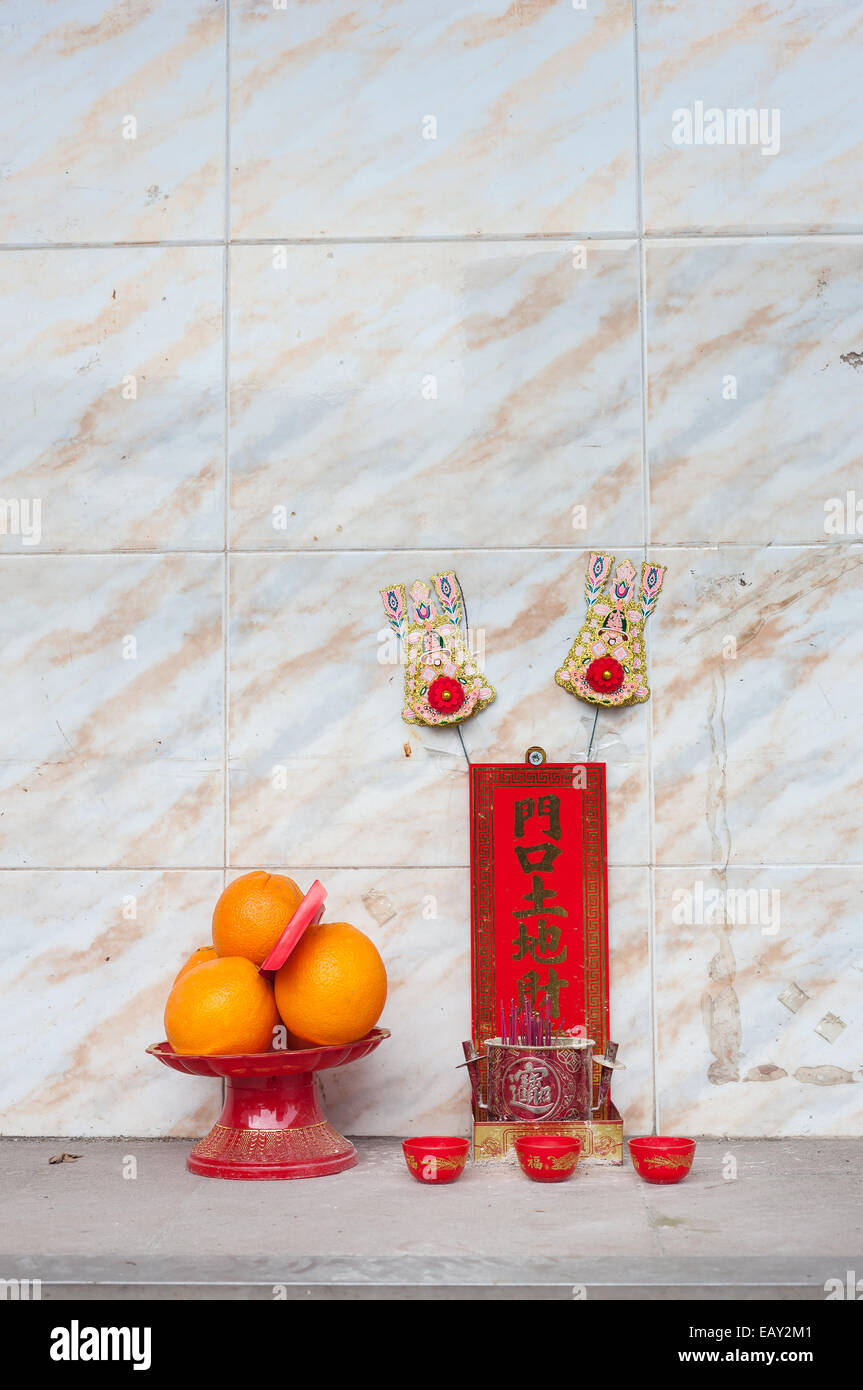 Hong Kong street santuario con frutta e bastoncini di incenso. Foto Stock