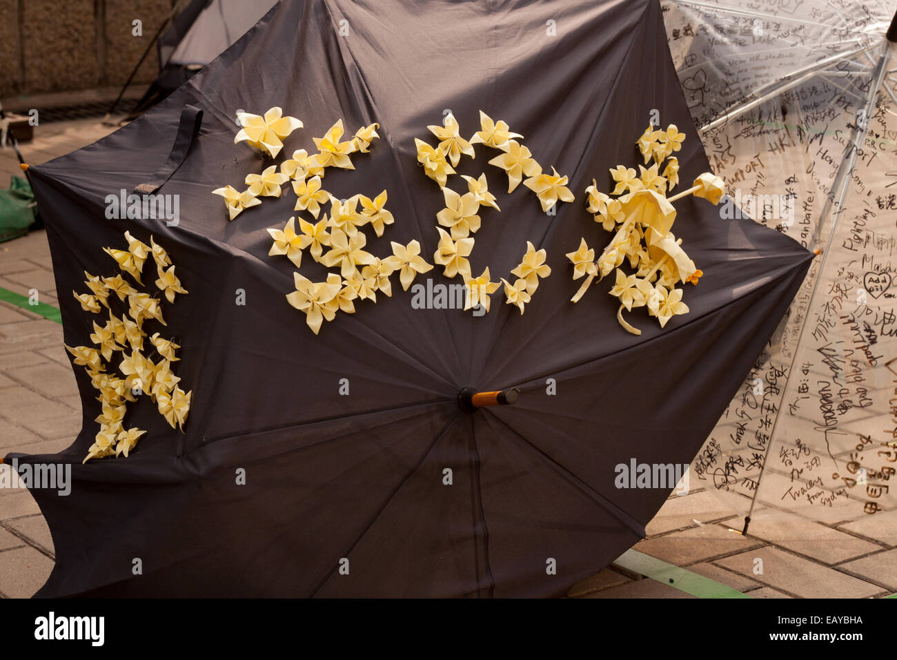 Ombrello nero decorato con carta gialla fiori e ombrelloni in Admiralty, Hong Kong Foto Stock