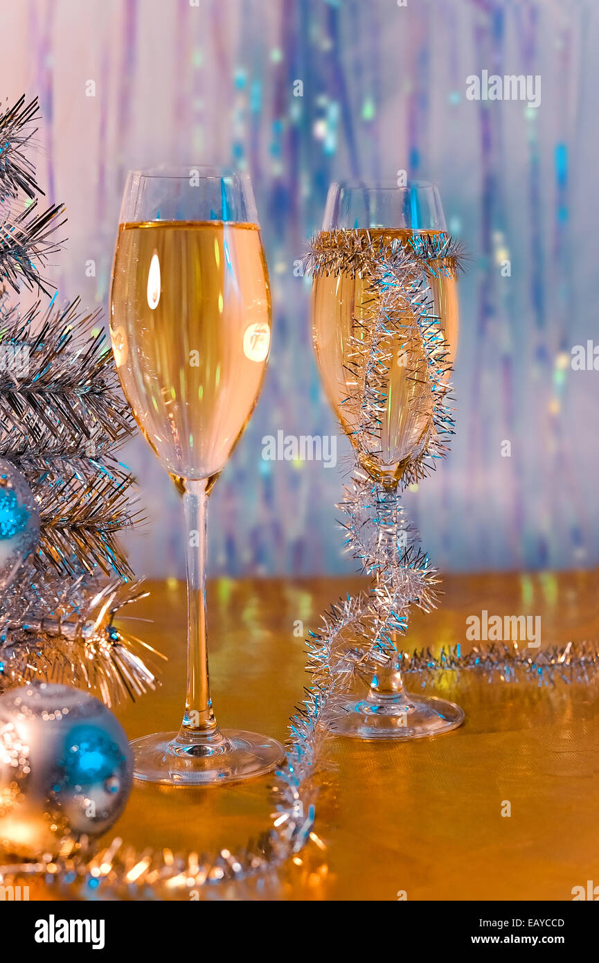 Bicchieri di vino, tinsel, albero di Natale e giocattoli sulla superficie d'Oro Foto Stock