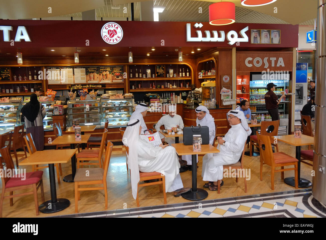 I passeggeri aventi uno snack a Costa internazionale della catena di caffè prima di bording il loro volo. Alla partenza il lounge. Il Bahrein ha una popolazione di oltre il 55% degli immigrati e tenuto le elezioni generali in questo giorno che è stato boicottato dai partiti di opposizione. Foto Stock