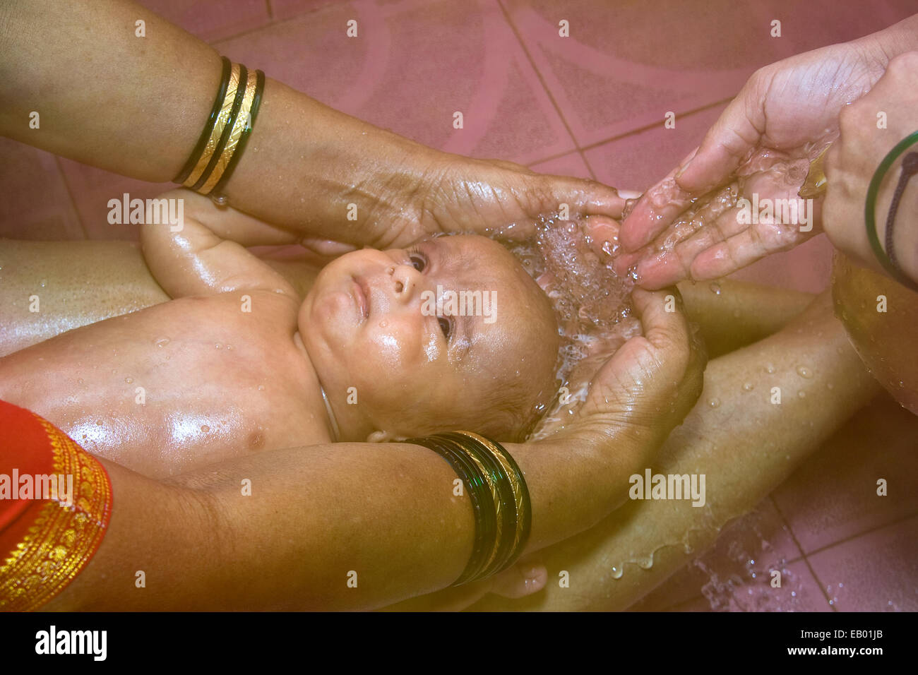 Un bambino indiano avente tradizionale, rilassante acqua calda bagno di testa Foto Stock