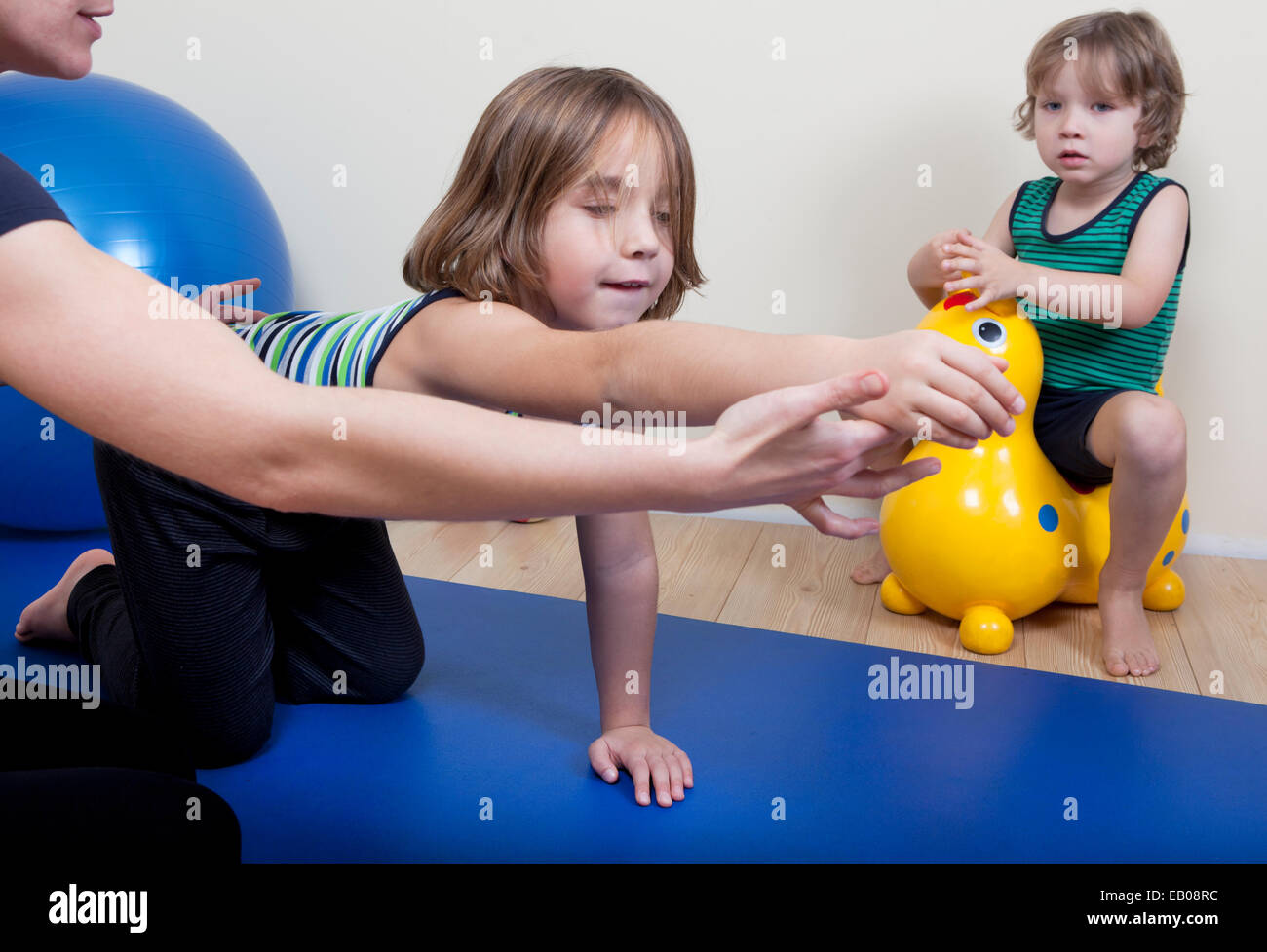 Una femmina di fisioterapista rende di fisioterapia con bambini piccoli Foto Stock