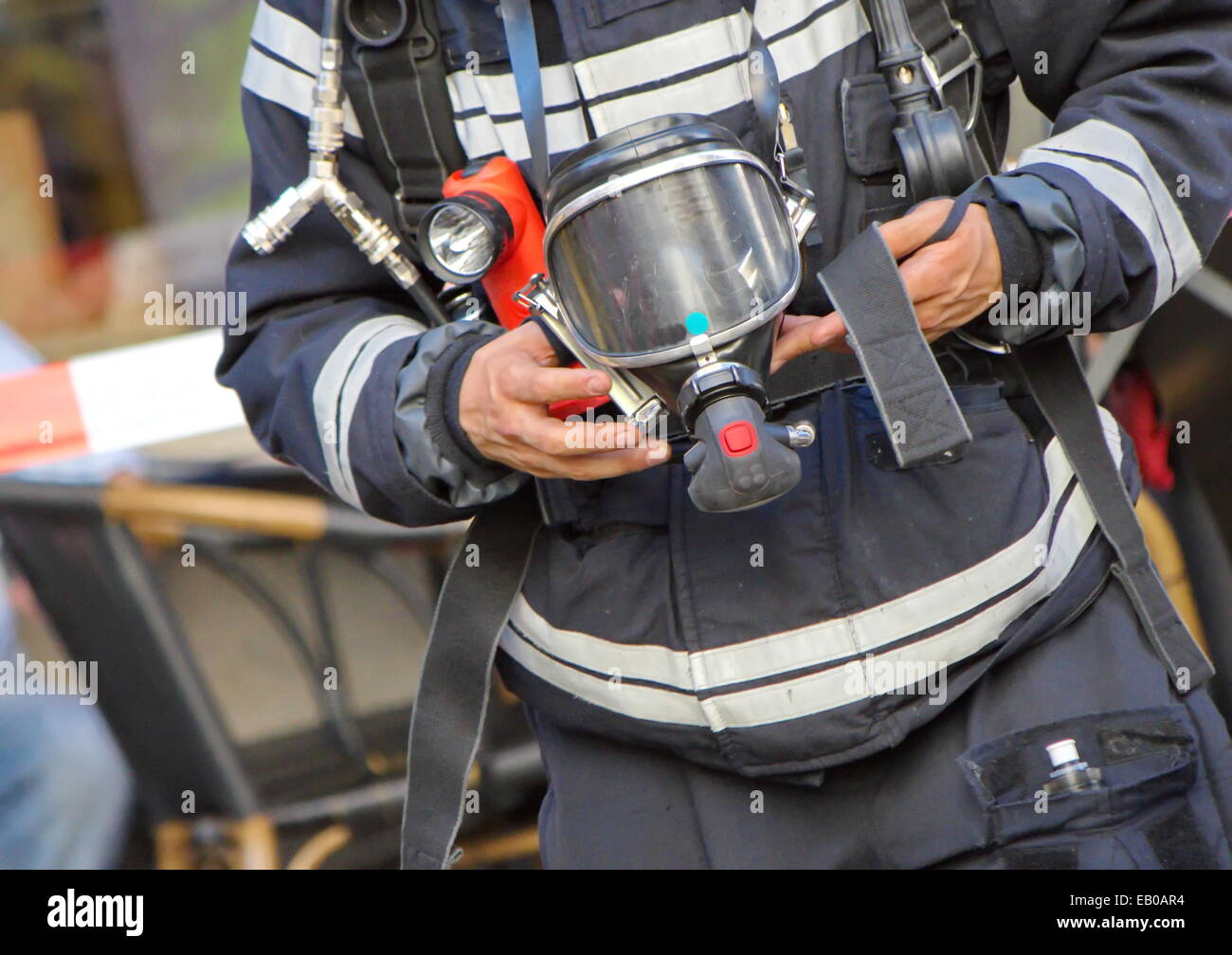 Chiudere fino a firefighter uomo con ossigeno o gas mask nelle sue mani Foto Stock