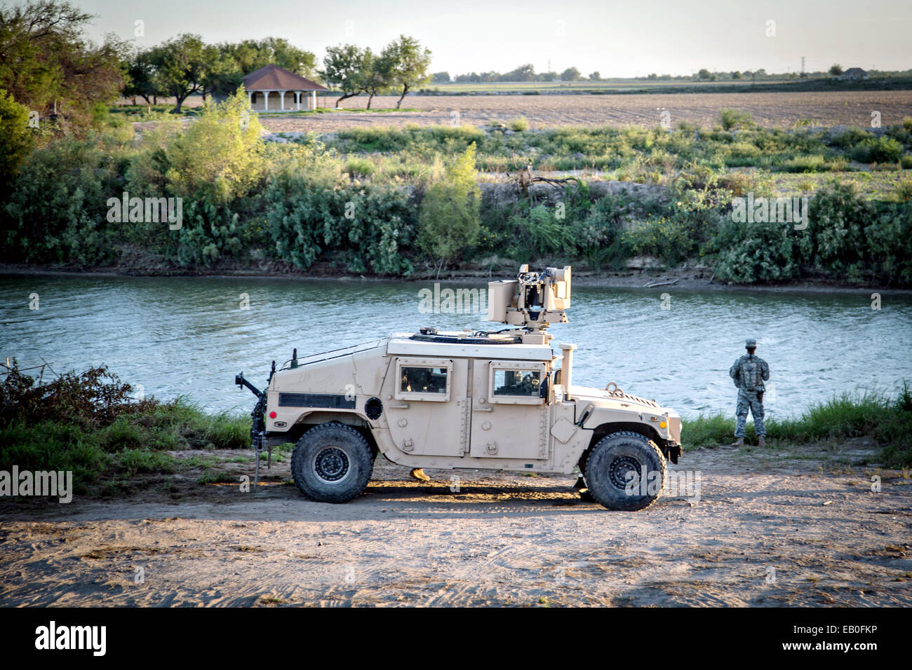 Un soldato dell'esercito Texas Guardia Nazionale osserva una sezione del Fiume Rio Grande lungo il confine Texas-Mexico a sostegno del funzionamento di sicurezza forte per aiutare a guardia del confine Settembre 11, 2014 in McAllen, Texas. Foto Stock