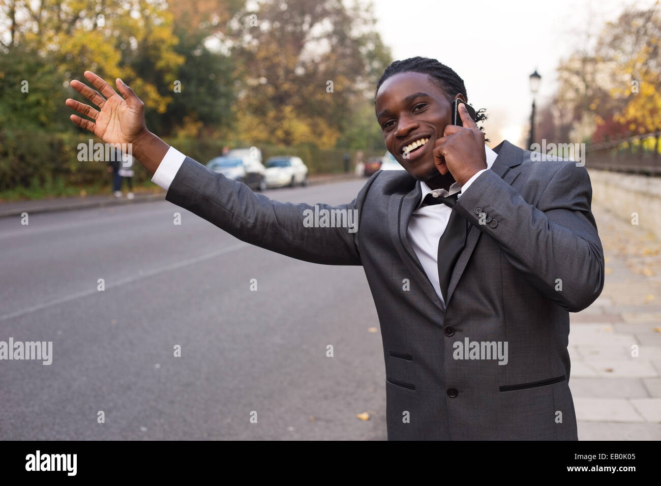 Business man salutando un taxi sul telefono. Foto Stock