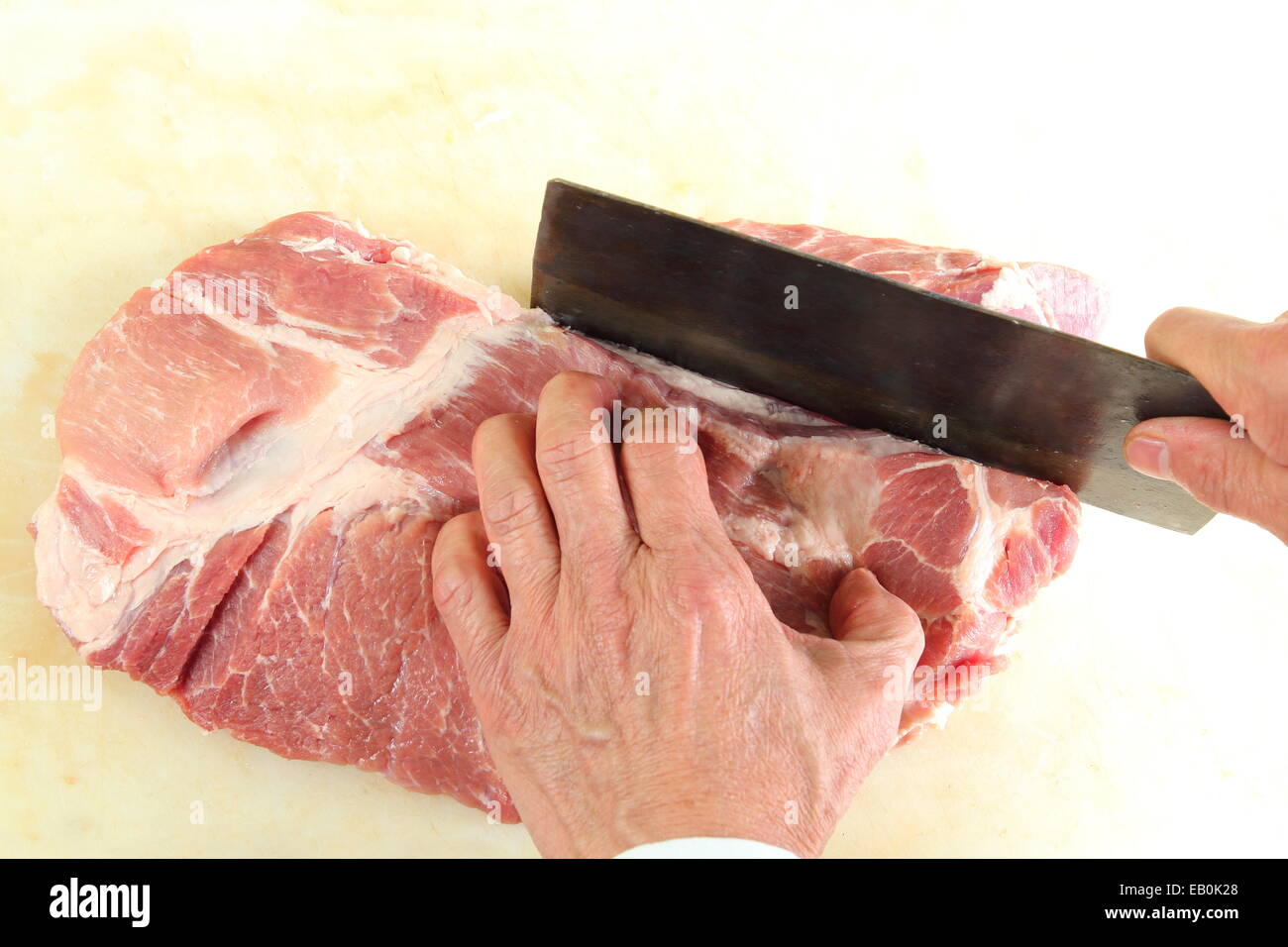 Un macellaio il taglio di una grande pice di carne Foto Stock