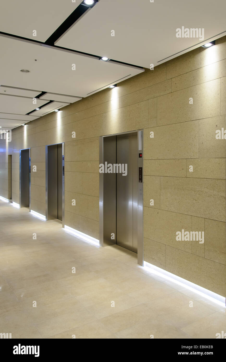 Tre porte di ascensori in un edificio per uffici Foto Stock