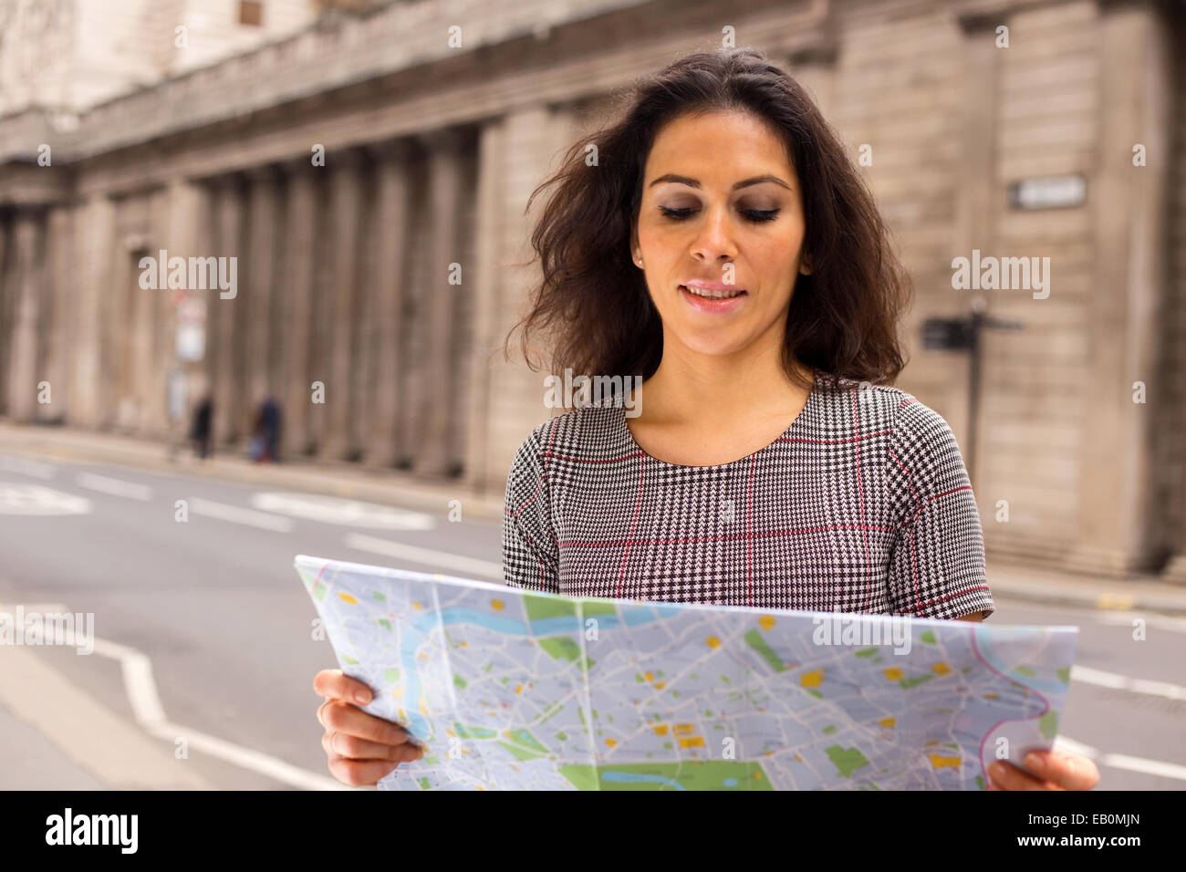 Giovane donna la lettura di una mappa della città Foto Stock