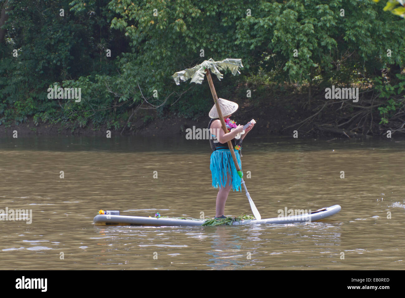 La donna canta e suona un ukulele galleggiando giù un fiume su una tavola  da surf con un albero di palma in Asheville qualcosa che galleggia gara  Foto stock - Alamy