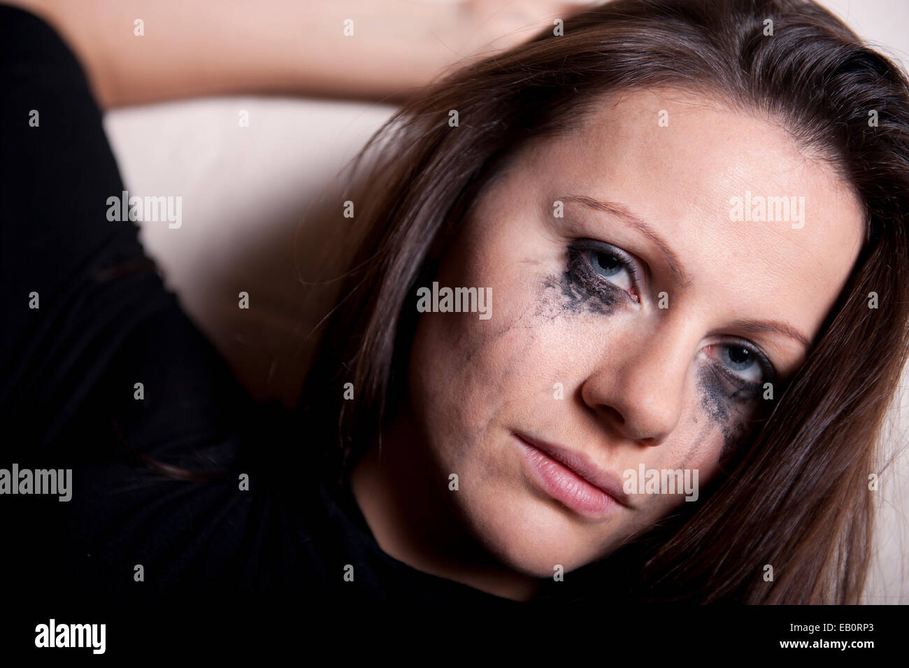 Close up ritratto di un molto sconvolto giovane donna con il make up correndo giù per il suo volto. Foto Stock