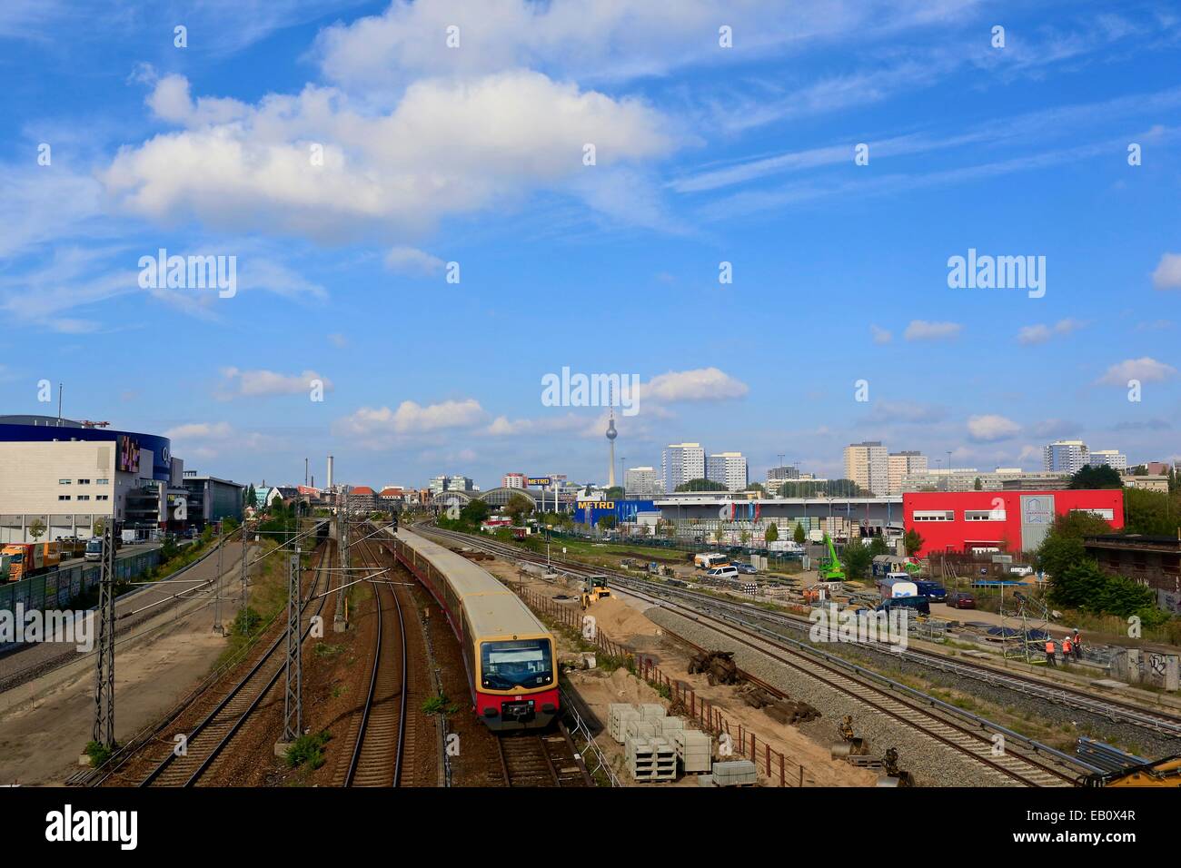 Infruttura ferroviaria con treno che passa per il neonato dello skyline di Berlino Foto Stock