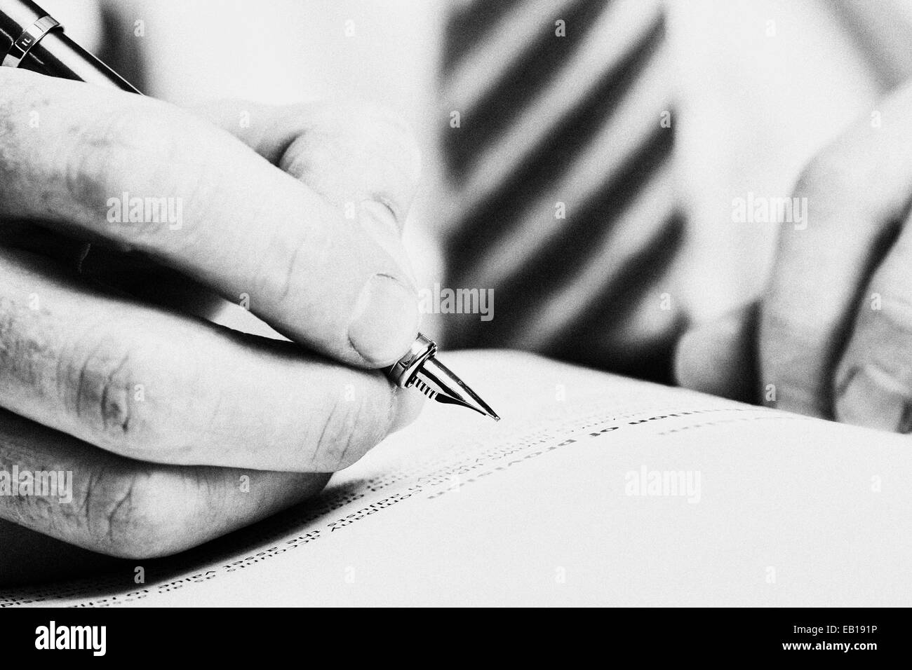 Una mano che tiene una penna stilografica e circa a scrittore di una nota o di evidenziare del testo per la correzione. Foto Stock