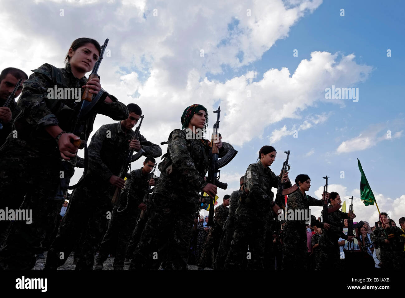 Combattenti curdi del popolo della unità di protezione YPG e la donna della unità di protezione YPJ prendendo parte a una cerimonia funebre per i combattenti curdi uccisi da uno Stato islamico o ISIS ISILmilitants in un cimitero vicino la città di Al-Malikiyah anche chiamato Derek ( ) curda in Al Hasakah o distretto Hassakeh nella Siria settentrionale Foto Stock