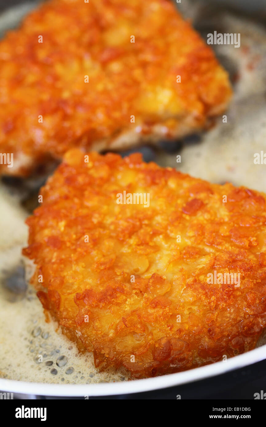 Croccante filetto di pollo nella padella, primo piano Foto Stock