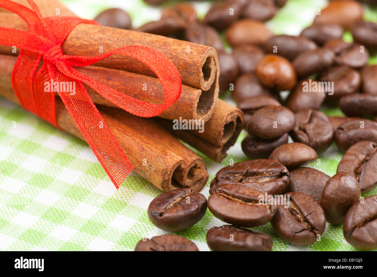 Bastoncini di cannella con un nastro rosso e i chicchi di caffè Foto Stock