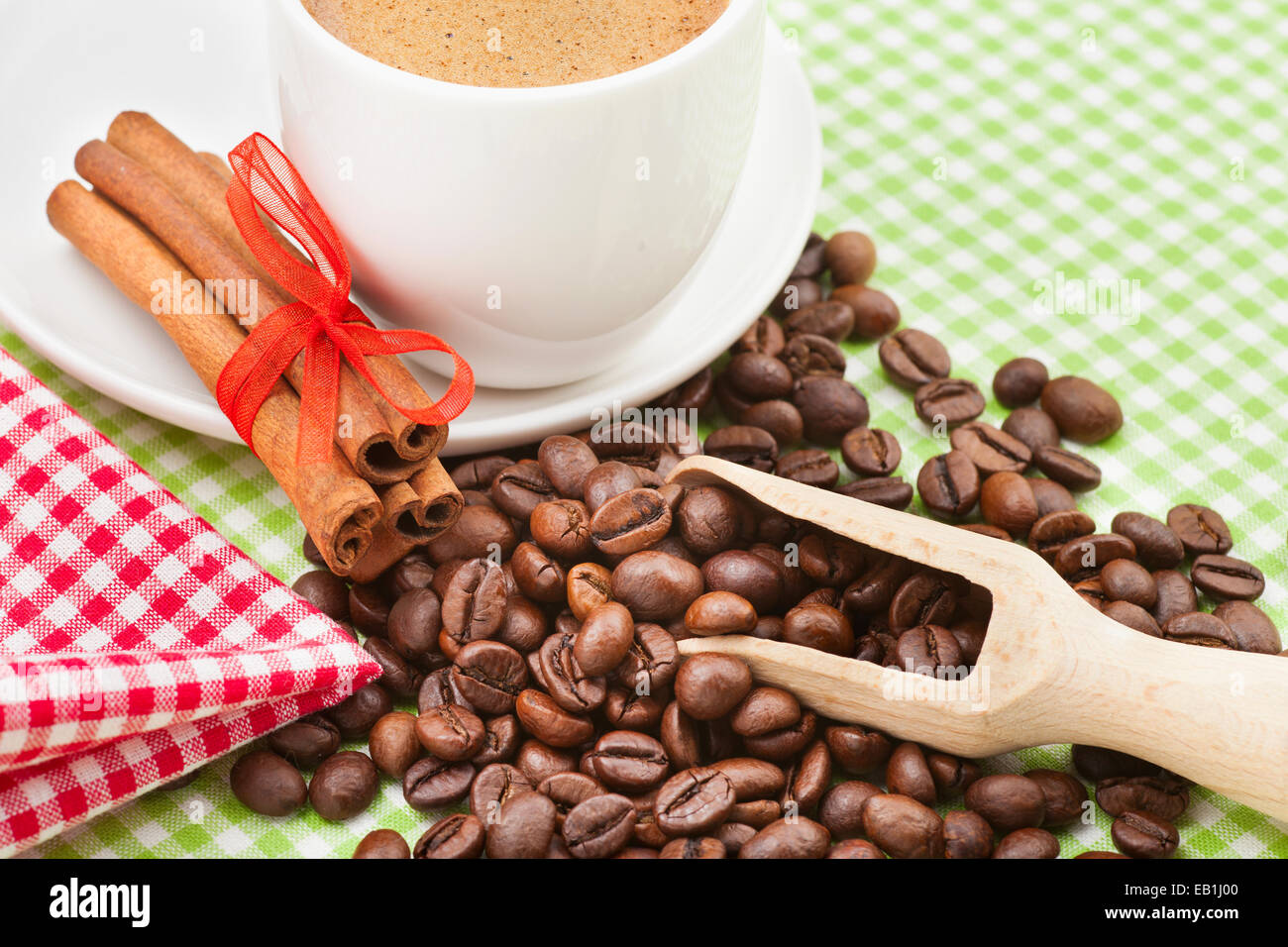 Tazza da caffè, bastoncini di cannella e i chicchi di caffè sul tavolo da cucina Foto Stock