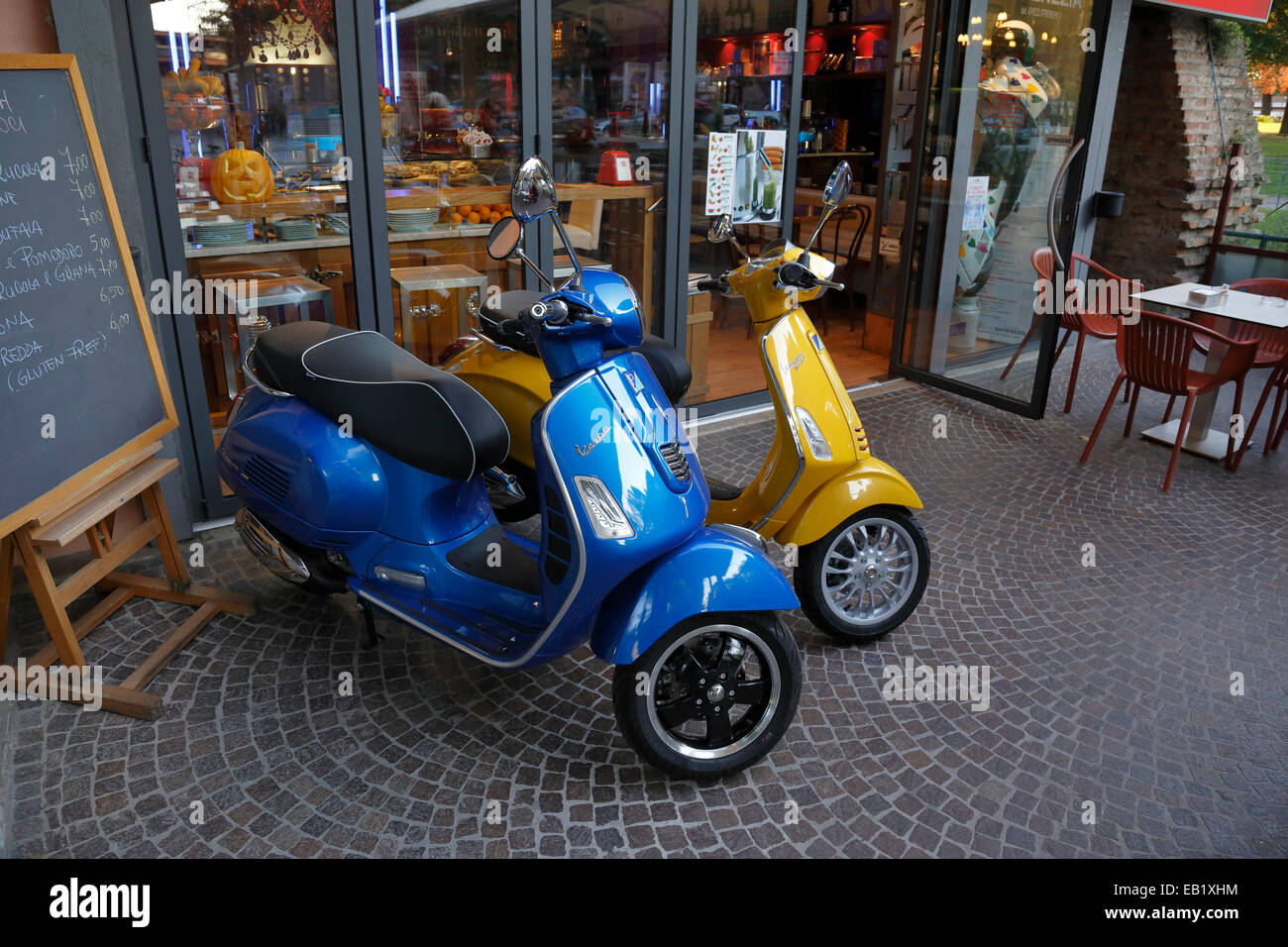 Nuova Vespa scooter sul display al di fuori di un cafe a Treviso, Italia, Veneto. Foto Stock