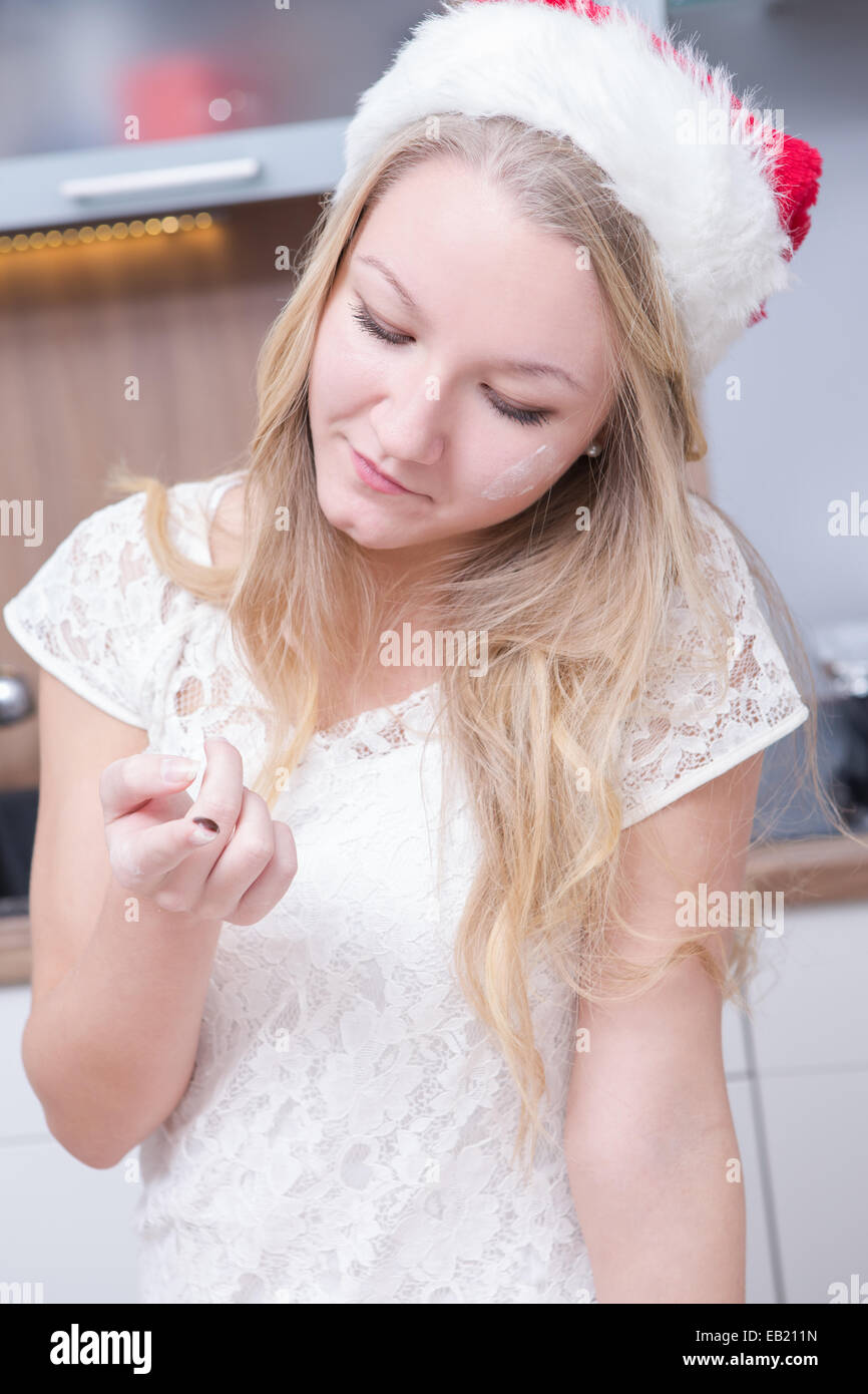 Ragazza rendendo biscotti natalizi a casa Foto Stock