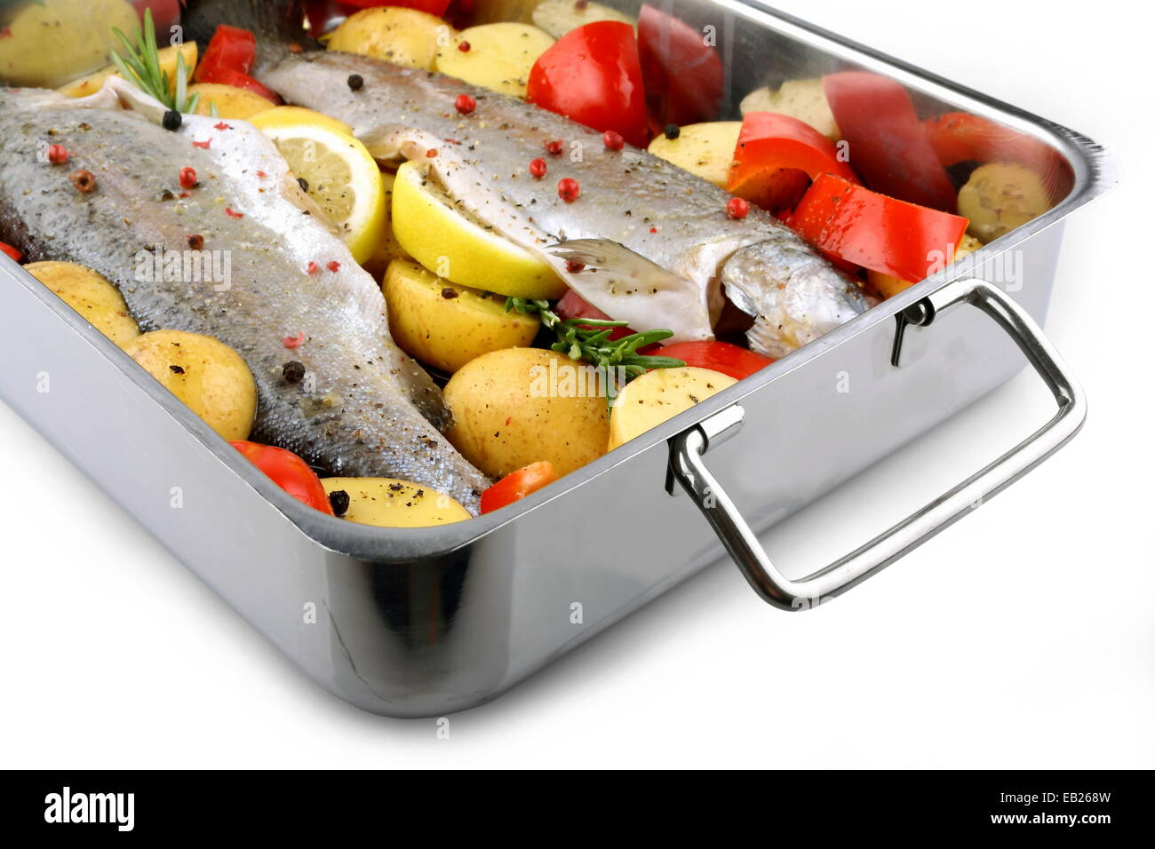 Due trote con patate e peperoni sulla teglia, isolato Foto Stock