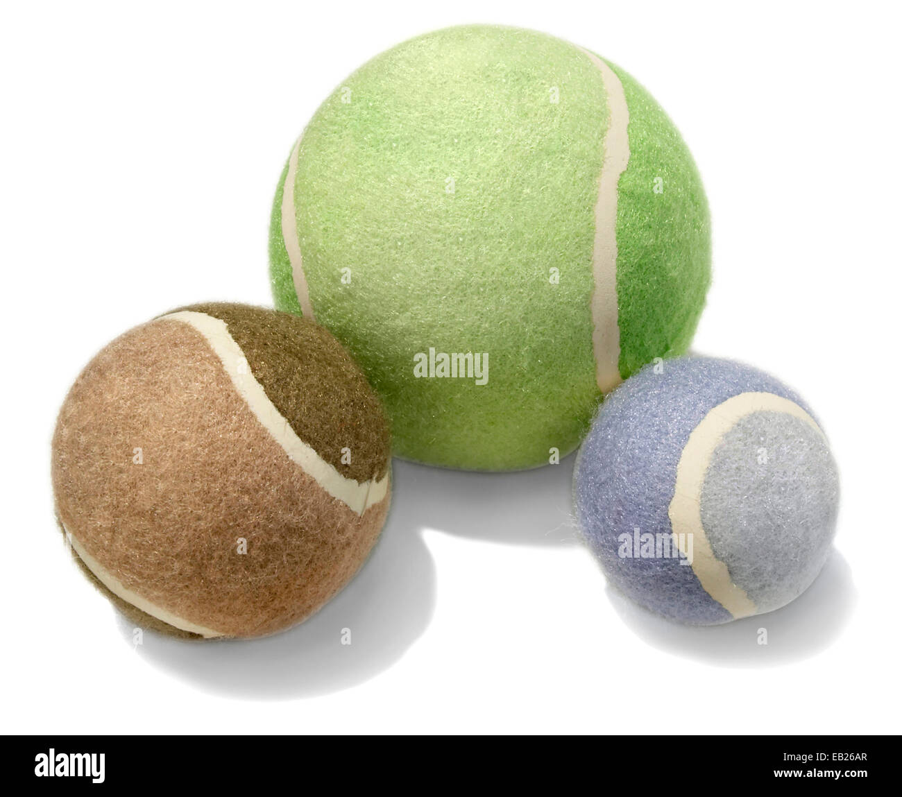 Tre palle da tennis giocattolo per cani di varie dimensioni e colori fotografate su sfondo bianco. Foto Stock
