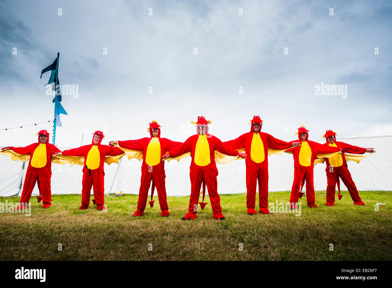 Sette uomini vestiti di rosso gallese draghi al grande tributo music festival Aberystwyth Regno Unito a Ferragosto 2014 Foto Stock