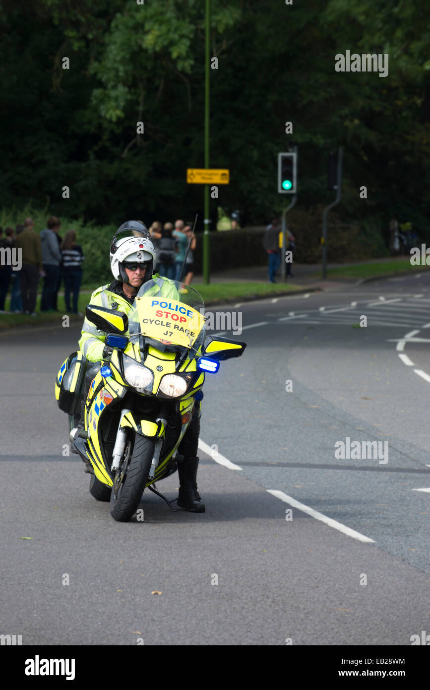 Un motociclista di polizia esegue una gabbia di chiusura della strada per il tour della Gran Bretagna Cycle Race Foto Stock