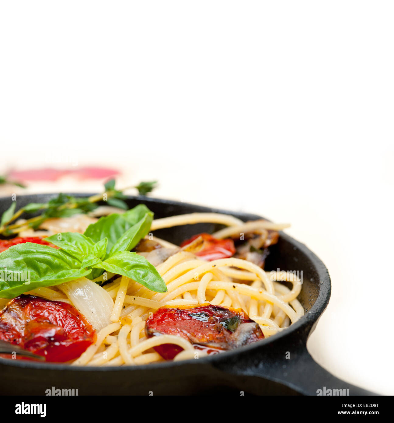 Italian spaghetti cotti al forno con pomodori e basilico e salsa di timo in una padella in ghisa Foto Stock