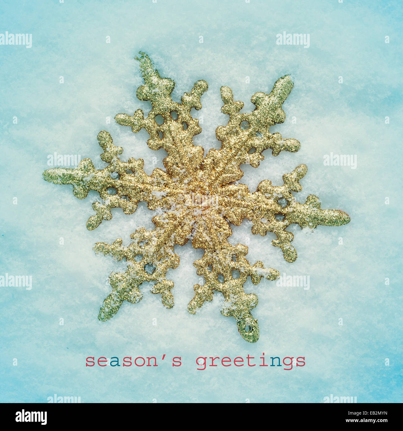 Un fiocco di neve dorata a forma di stella di Natale sulla neve e la frase i migliori auguri di Buon Natale con un effetto retrò Foto Stock