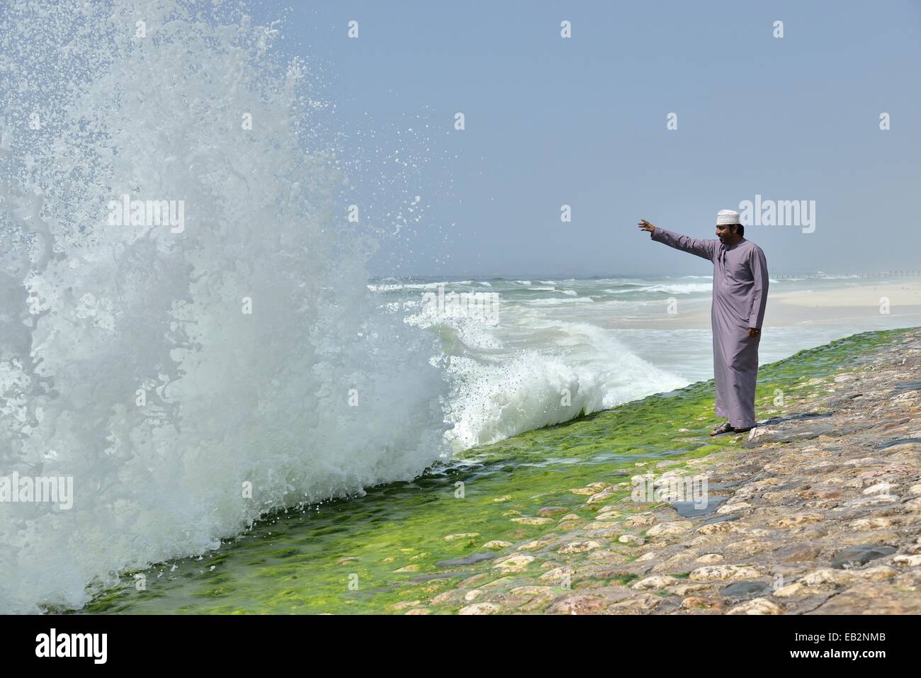 Uomo locale a guardare il surf alla corniche di Salalah durante la stagione dei monsoni, o Khareef stagione, Salalah, regione di Dhofar Foto Stock